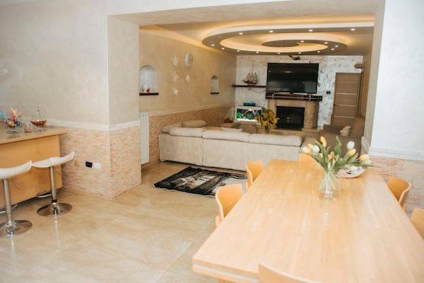 soggiorno ampio con soffitto decorato tavolo e angolo bar
