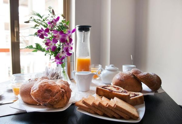 colazione con succo di frutta cornetti torte fiori decorativi 