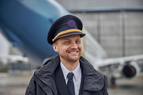 Ritratto dell'equipaggio dell'aereo, felice e sicuro, vicino all'aereo.