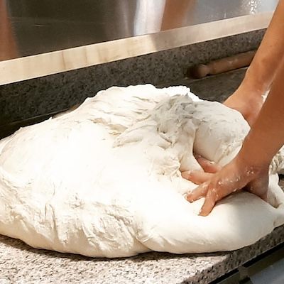 pizzaiolo che sta impastando una pizza