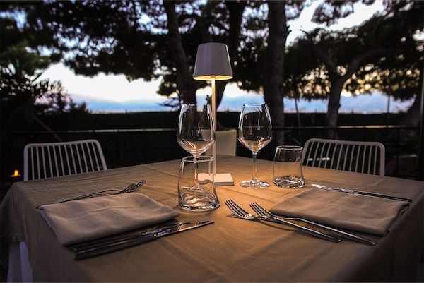 una tavola imbandita ristorante al tramonto posate e bicchieri