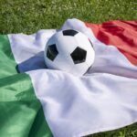 Pallone da calcio sulla superficie della bandiera italiana sull'erba verde, partita inaugurale del campionato europeo di calcio