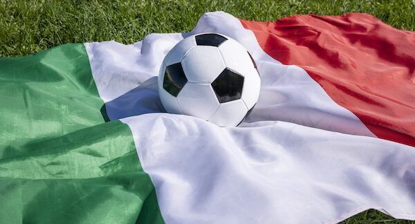Pallone da calcio sulla superficie della bandiera italiana sull'erba verde, partita inaugurale del campionato europeo di calcio