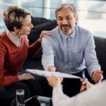 assicuratore con firmatari del contratto all'interno di un ufficio di una compagnia assicurativa