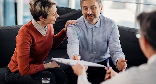 assicuratore con firmatari del contratto all'interno di un ufficio di una compagnia assicurativa