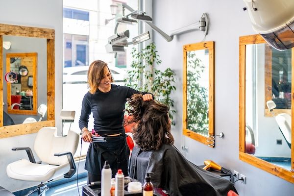 Parrucchiera e donna in un salone di bellezza.