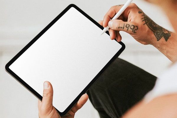uomo tatuato che lavora su un mockup dello schermo del tablet