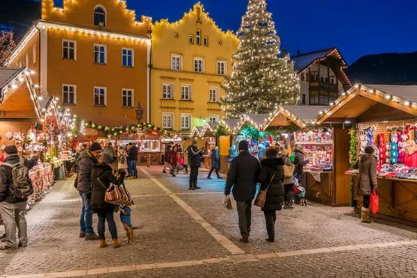 Persone che camminano tra i venditori durante una festa di Natale