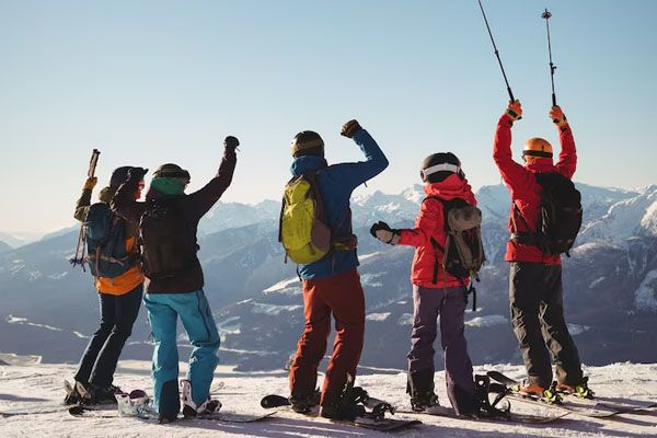 Sciatori che festeggiano in piedi su una montagna innevata