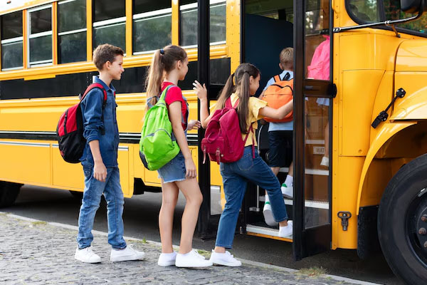 Bambini che salgono su uno scuolabus