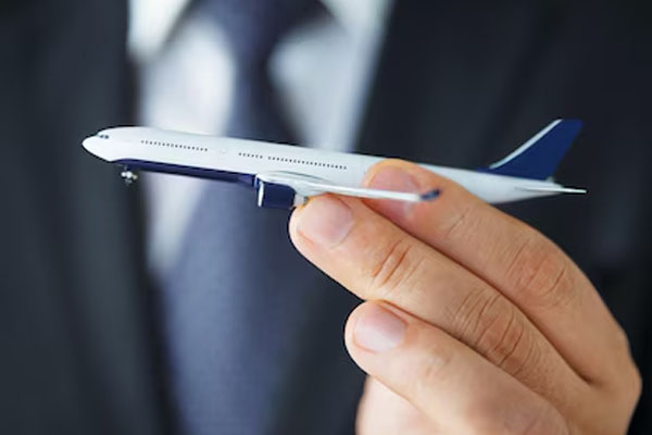 Primo piano di una mano che regge un modellino in scala di un aereo di linea